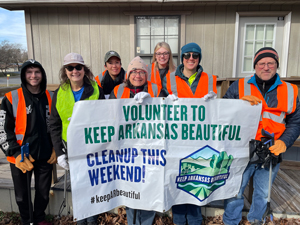 Volunteer To Keep Arkansas Beautiful sign held by clean up crew. 