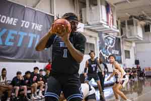 Taylor Harrell holding the basketball on court during a game.